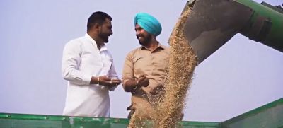 two Rice Farmers in India talking next to farm equipment